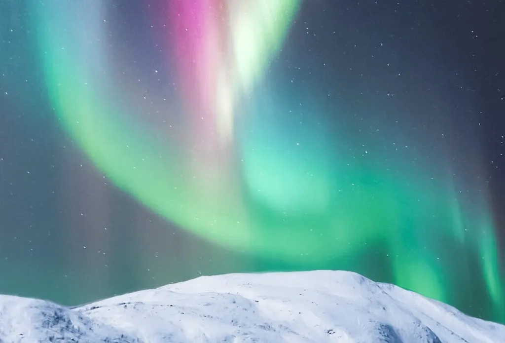 colorful polar lights over snowy mountain